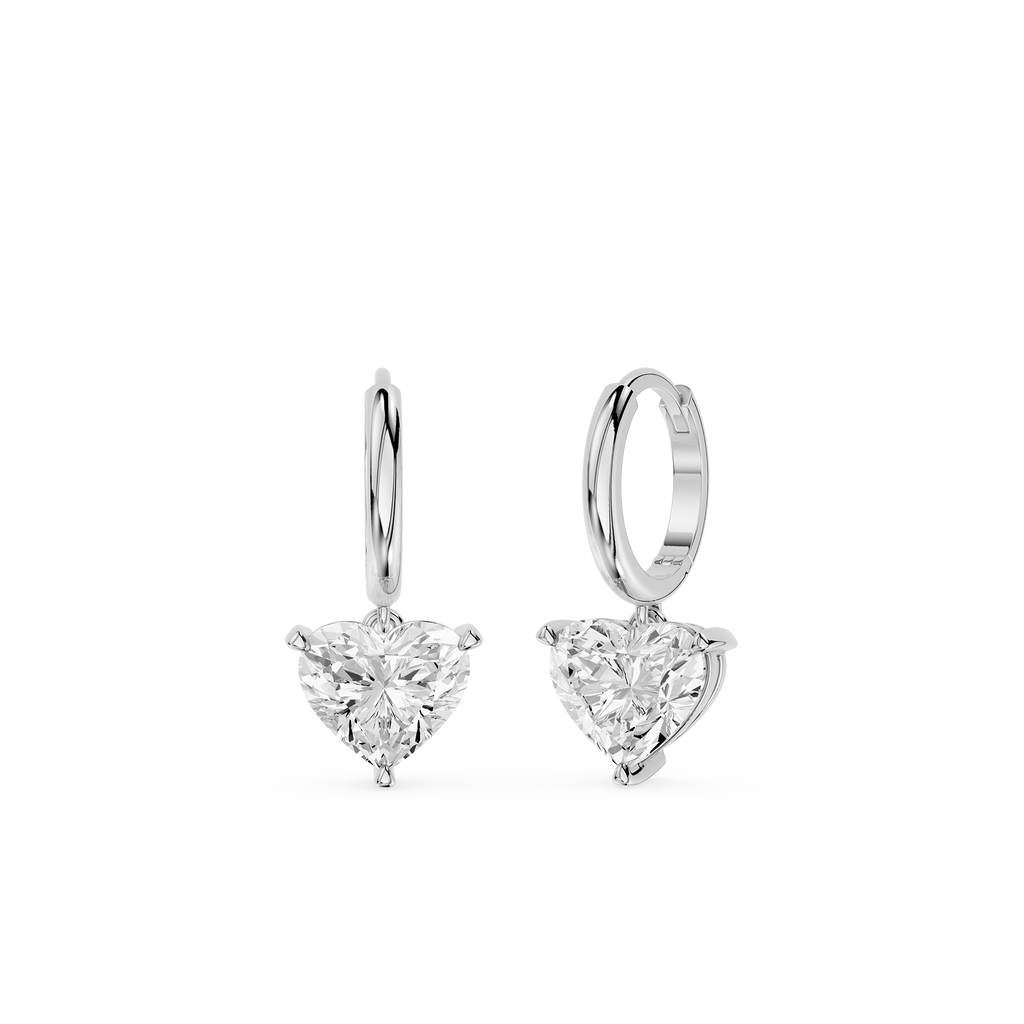 Pair of silver hoop earrings with heart-shaped clear gemstones on a white background