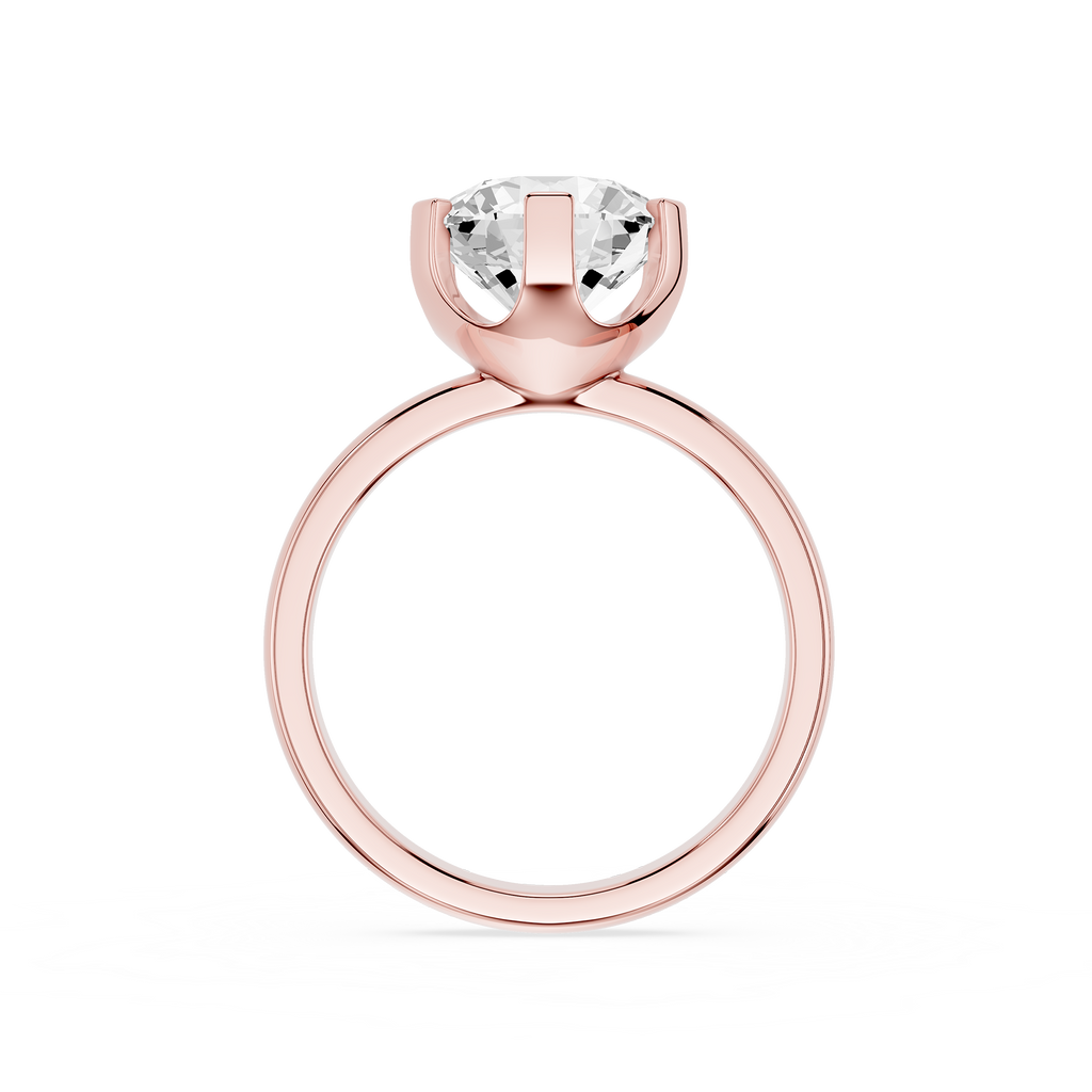 Rose gold ring with a clear gemstone on a white background