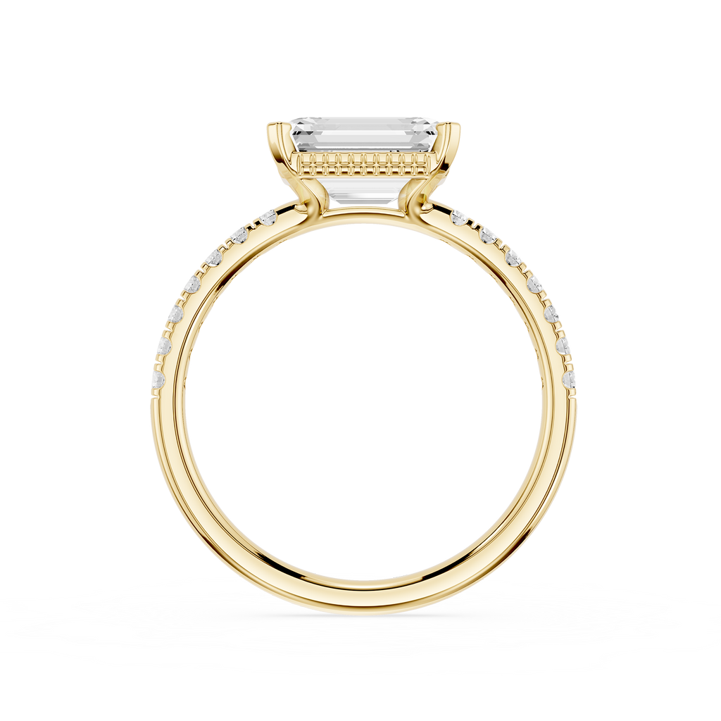 A yellow gold ring featuring a rectangular baguette-cut clear gemstone in a prong setting, with a pavé band accented by small round diamonds, shown on a plain white background.