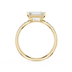 A yellow gold ring featuring a rectangular baguette-cut clear gemstone in a prong setting, with a pavé band accented by small round diamonds, shown on a plain white background.