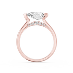 An asymmetrical half bezel secures the east west pear lab diamond on this rose gold ring with a smooth rounded shank