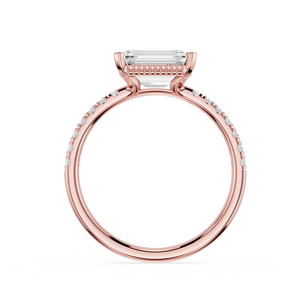 A rose gold engagement ring featuring a rectangular emerald-cut clear center stone and pavé-set round diamonds along the shank, shown on a clean white background.