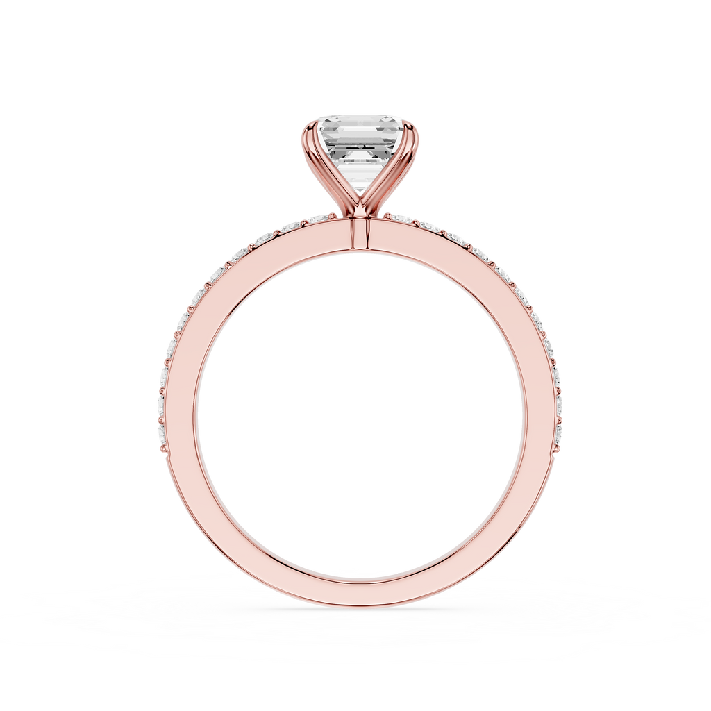 A Rose-toned diamond ring featuring a rectangular cushion-cut center stone in a four-prong setting, with a halo of small round diamonds along the band, shown against a plain white background.