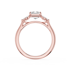 A rose gold ring with a heart-shaped clear gemstone in the center and smaller side stones, shown on a plain white background.