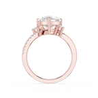 Rose gold ring with a large round-cut center stone and small pavé-set stones along the shank, shown on a plain white background.