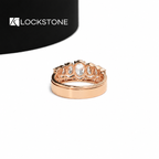 A graduated oval lab diamond wedding ring sits alongside a rose gold anniversary band with flush round diamond detailing