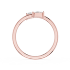A rose gold ring with a three-stone setting, featuring clear round-cut gemstones, shown from a top-down view on a white background.
