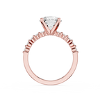 A rose gold engagement ring featuring a triangular-cut diamond solitaire center stone and a halo of small round diamonds along the shank, shown on a plain white background.