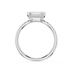 A silver-toned engagement ring featuring a rectangular baguette-cut center stone in a prong setting, with a micro-beaded halo and a pavé-set shank, shown on a solid white background.