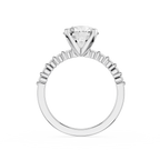 A silver-toned solitaire engagement ring featuring a large round-cut diamond center stone in a four-prong setting, with a shank accented by small baguette diamonds, shown on a plain white background.