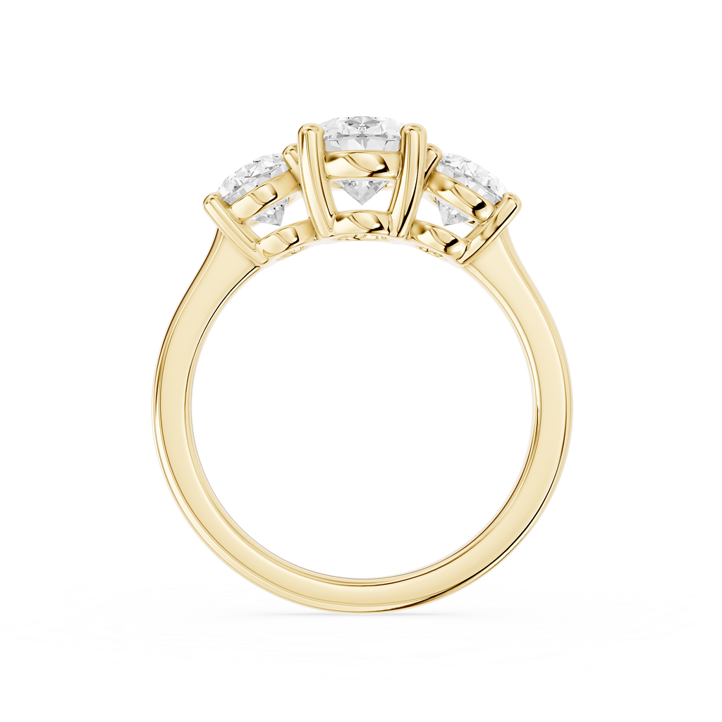 Oval diamond trilogy engagement ring in yellow gold displaying a prominent center stone flanked by two smaller oval diamonds