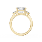 A prong set radiant lab diamond sits between step cut side diamonds on this yellow gold three stone engagement ring