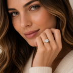 Woman wearing a gold ring with a diamond, close-up of face and hand.