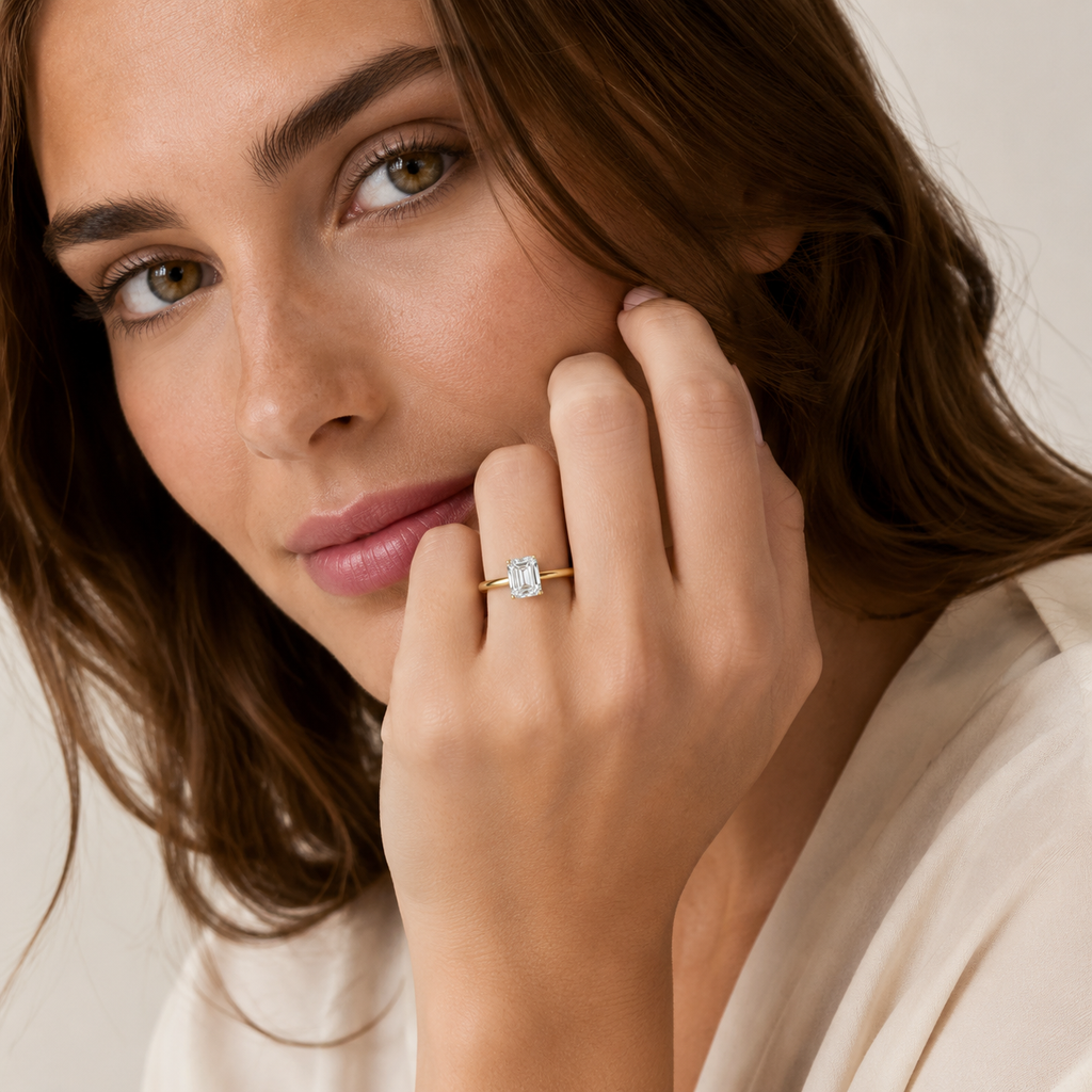 Close-up of a woman wearing a gold ring with a diamond on her finger.