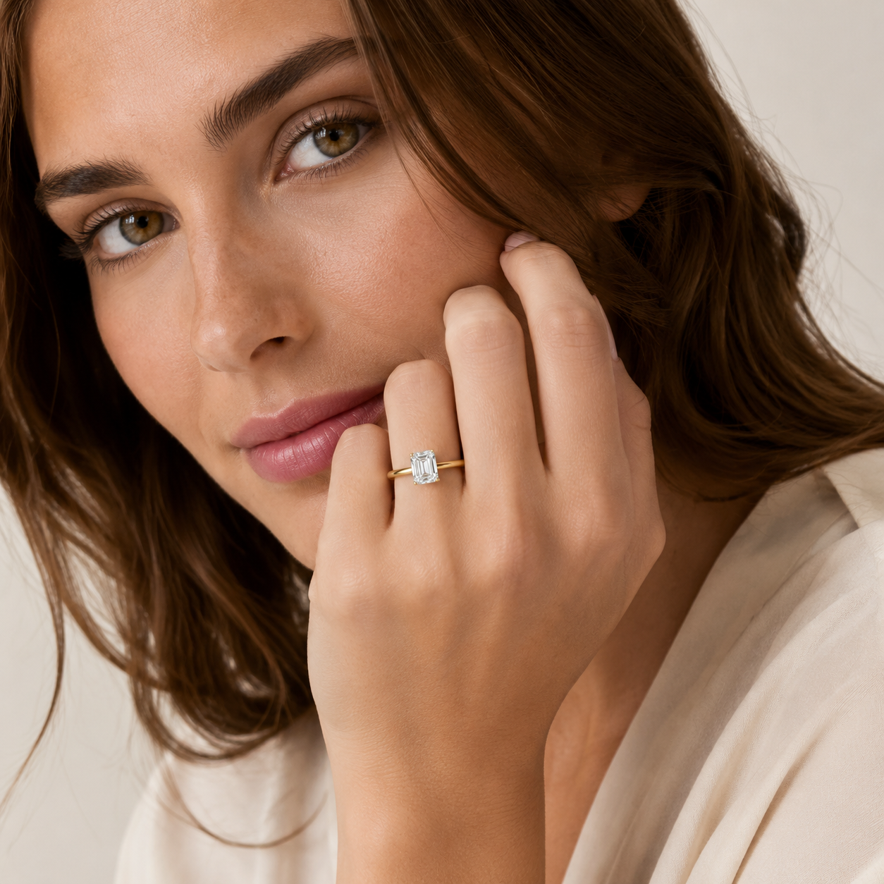 Close-up of a woman wearing a gold ring with a diamond on her finger.