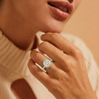 Close-up of a hand wearing a diamond ring with a soft background