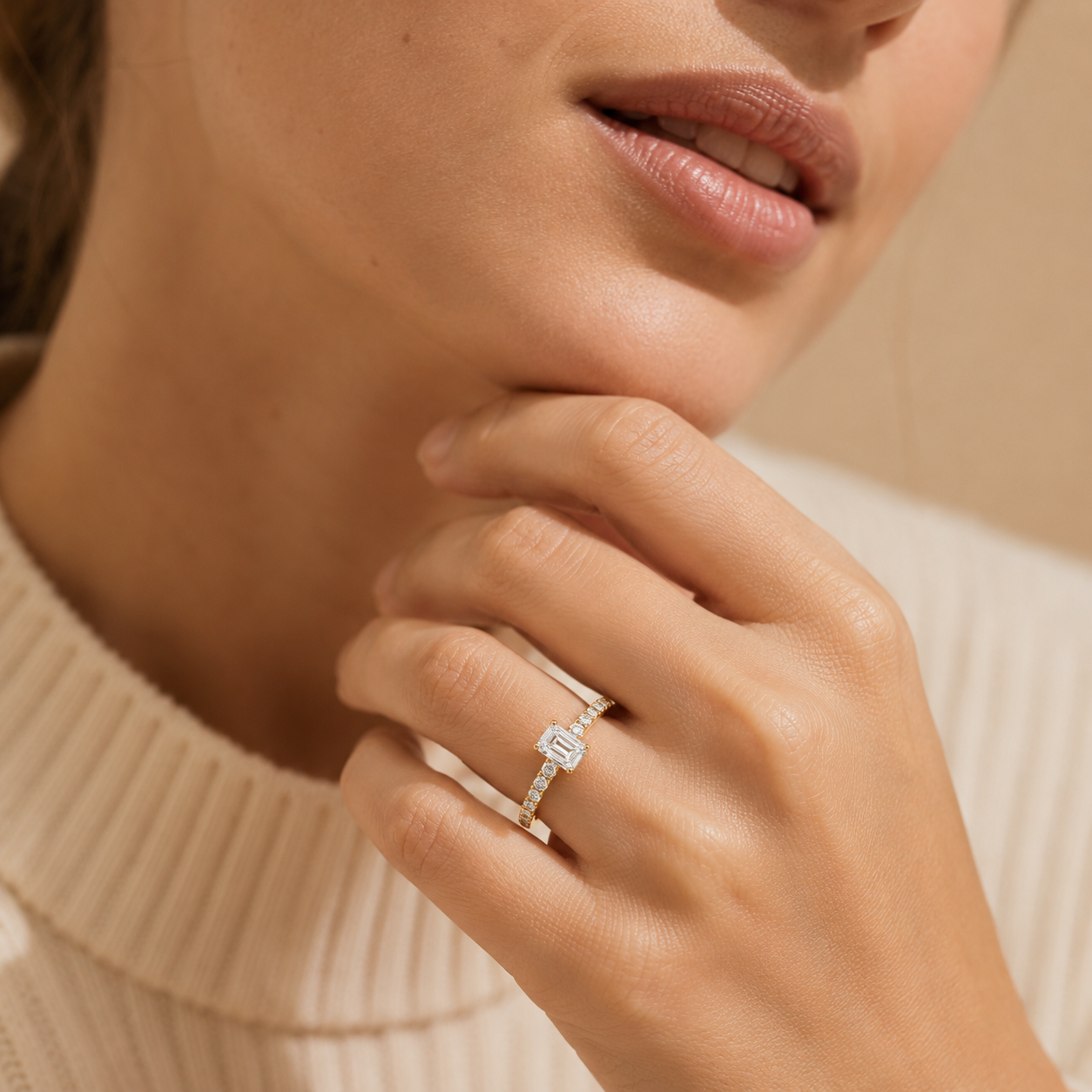 Close-up of a hand wearing a diamond ring with a neutral background