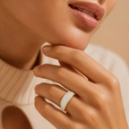 Close-up of a hand wearing a diamond ring with a blurred background