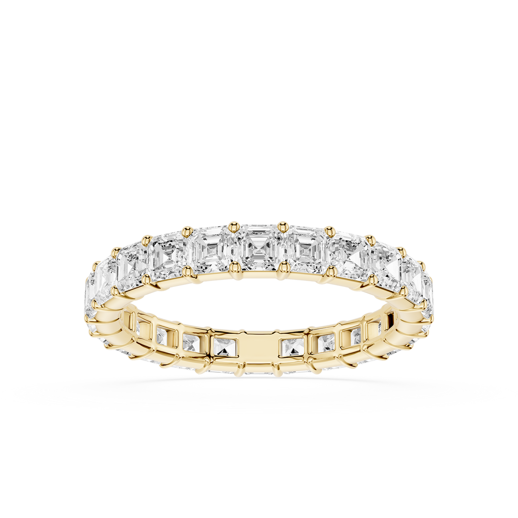A yellow gold eternity ring featuring a continuous row of baguette-cut clear diamonds on the top and smaller round diamonds on the sides, set against a plain white background.