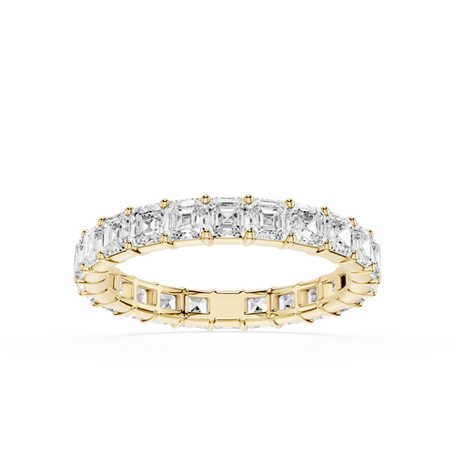 A yellow gold eternity ring featuring a continuous row of baguette-cut clear diamonds on the top and smaller round diamonds on the sides, set against a plain white background.