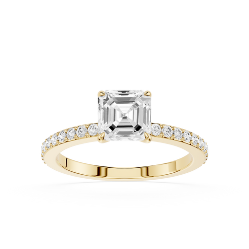 An emerald-cut diamond engagement ring in a Yellow-colored metal setting, featuring a pave band with small round diamonds, shot against a solid white background.