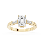 Gold ring with emerald-cut diamond and baguette side stones on a white background