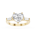 Gold ring with a heart-shaped diamond and two smaller diamonds on a white background
