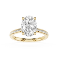 A yellow gold engagement ring featuring a large oval-cut center diamond in a four-prong setting, with a shank paved with small round diamonds, shown on a plain white background.