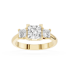 Gold ring with three princess-cut diamonds on a white background