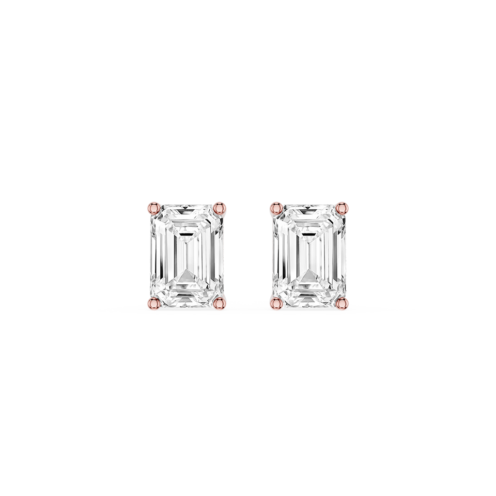 Pair of emerald-cut diamond stud earrings with rose gold prongs on a white background