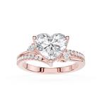 A rose gold engagement ring featuring a large heart-shaped clear gemstone in a prong setting, with a split band adorned with small pavé diamonds on a clean white background.