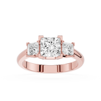 Rose gold ring with three princess-cut diamonds on a white background
