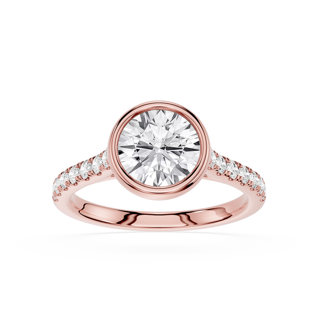 A rose gold engagement ring featuring a round brilliant-cut center stone in a bezel setting, with a pavé band accented by small round stones, shown on a clean white background.