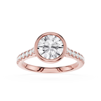 A rose gold engagement ring featuring a round brilliant-cut center stone in a bezel setting, with a pavé band accented by small round stones, shown on a clean white background.