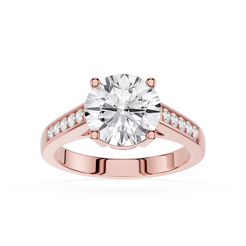 A rose gold engagement ring featuring a round-cut diamond center stone and small pavé diamonds along the split shank, set against a plain white background.