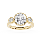 Gold ring with a large central diamond and two smaller diamonds on either side against a white background