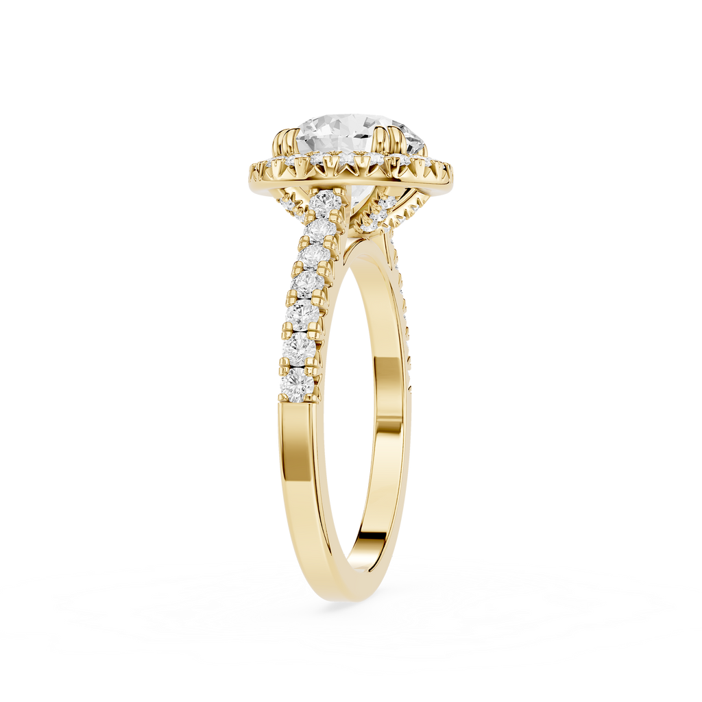 A Yellow gold engagement ring featuring a round-cut diamond center stone in a halo setting, with pave diamonds along the shank, shown on a plain white background.