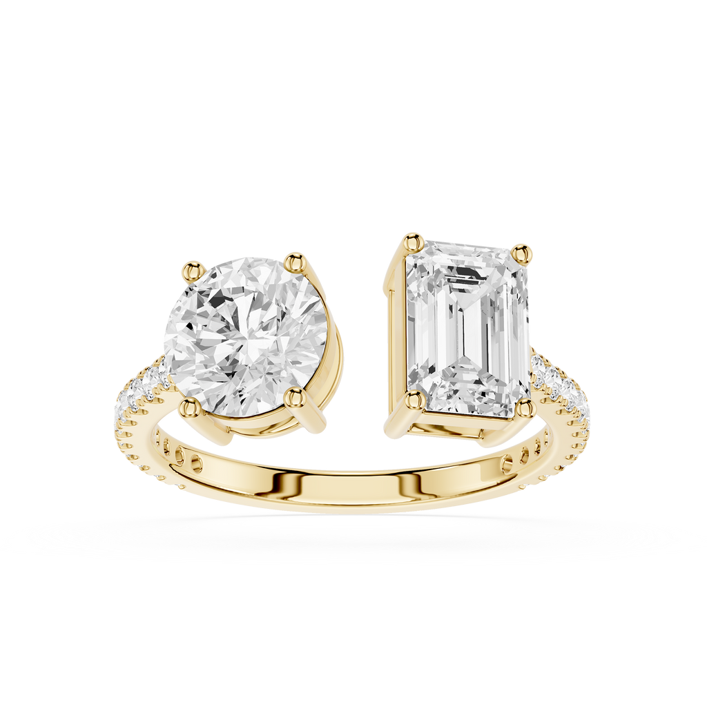 A white gold or platinum split-shank ring featuring a round brilliant-cut diamond on one side and an emerald-cut diamond on the other, set against a plain white background.