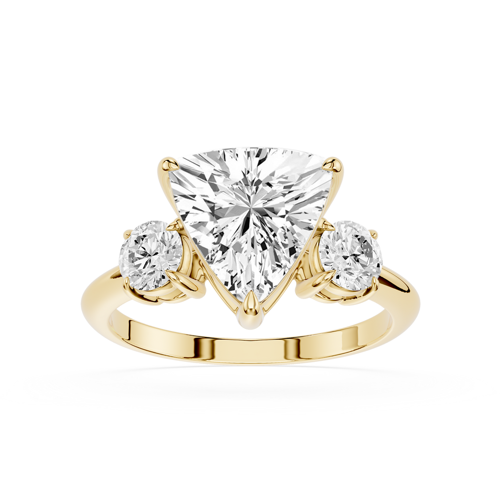 Gold ring with a heart-shaped diamond and two smaller diamonds on a white background