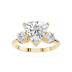 Gold ring with a heart-shaped diamond and two smaller diamonds on a white background