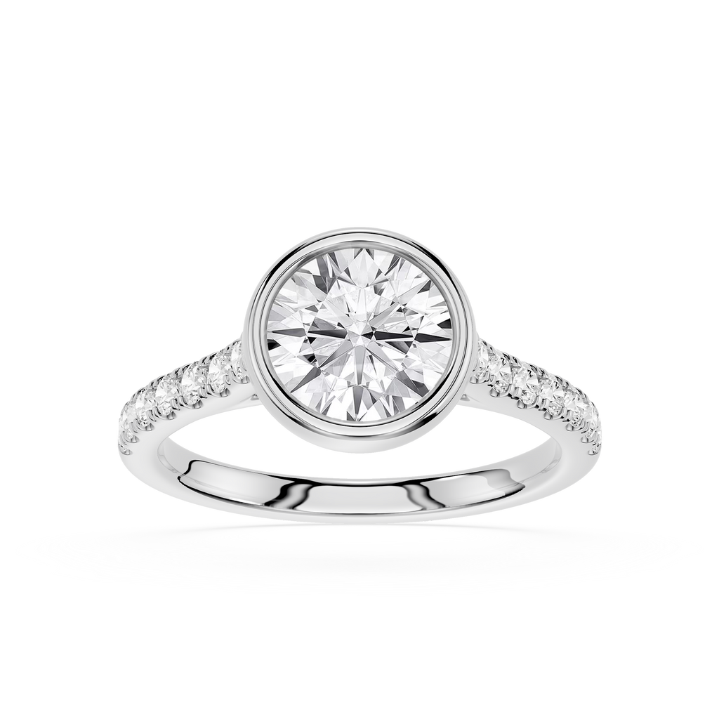 A round-cut diamond engagement ring in a polished silver-colored metal band with pavé-set diamonds along the shoulders, shown on a clean white background.