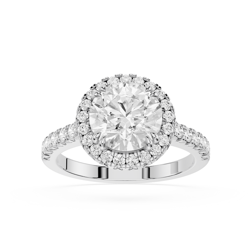 A silver-toned diamond engagement ring with a round-cut center stone, a halo of smaller diamonds, and a shank accented with pave diamonds, shown on a clean white background.