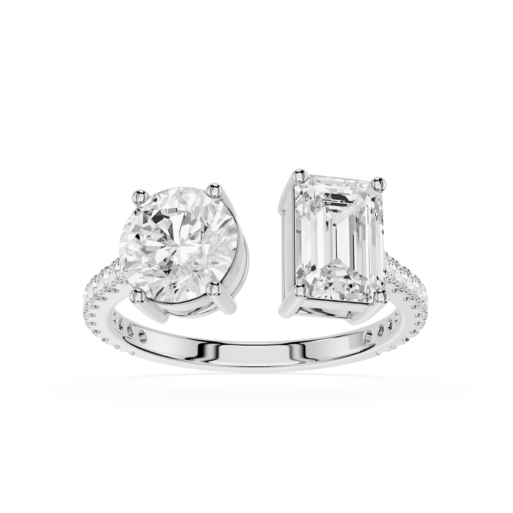 A white gold or platinum split-shank ring featuring a round brilliant-cut diamond on one side and an emerald-cut diamond on the other, set against a plain white background.