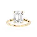 Gold ring with a large emerald-cut diamond on a white background