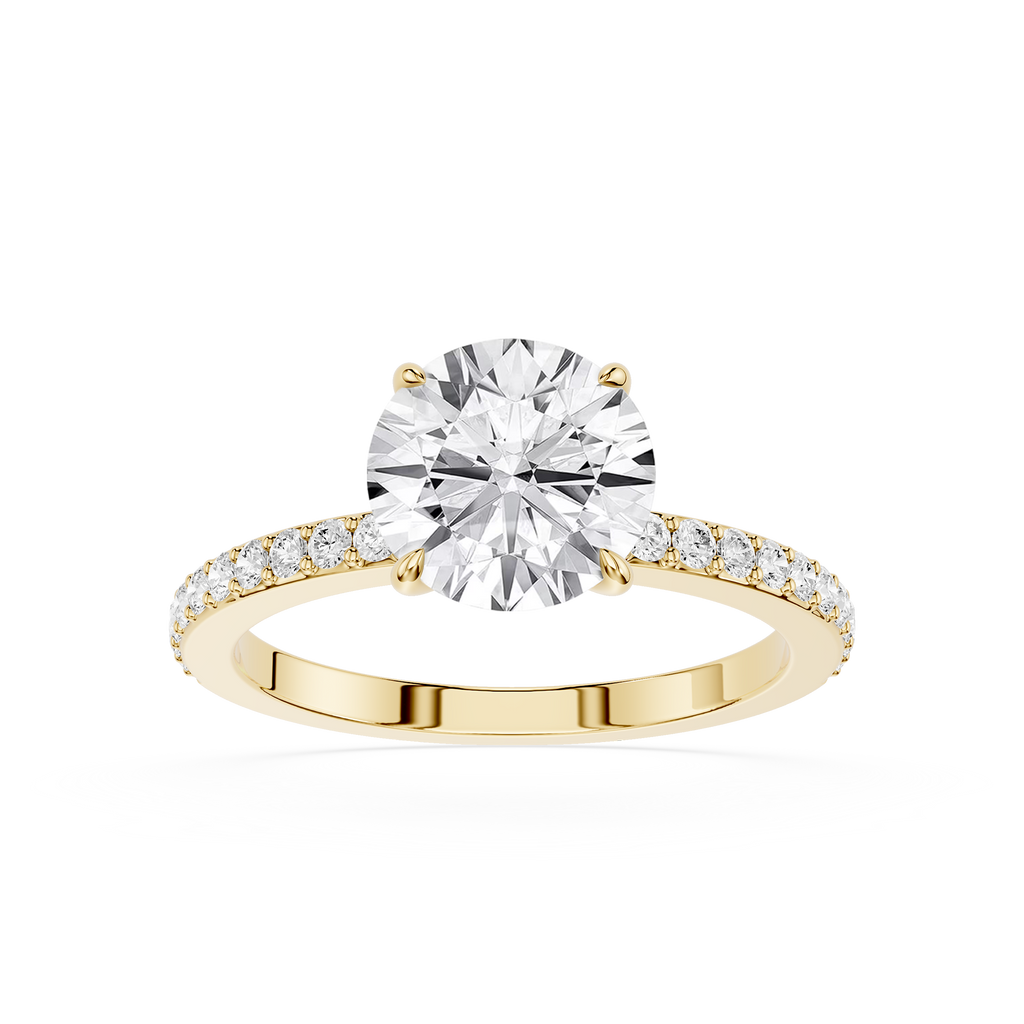 A yellow gold engagement ring featuring a round brilliant-cut diamond center stone and a pavé-set diamond band, shown on a clean white background.