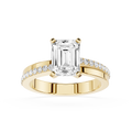 Gold ring with emerald-cut diamond and smaller diamonds on a white background
