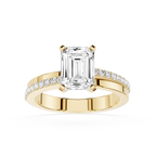 Gold ring with emerald-cut diamond and smaller diamonds on a white background