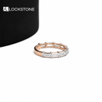 A row of step cut baguette diamonds lines the front of this rose gold anniversary ring with a slim polished band