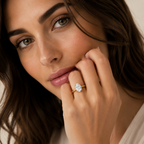 Close-up of a woman wearing a diamond ring on a neutral background