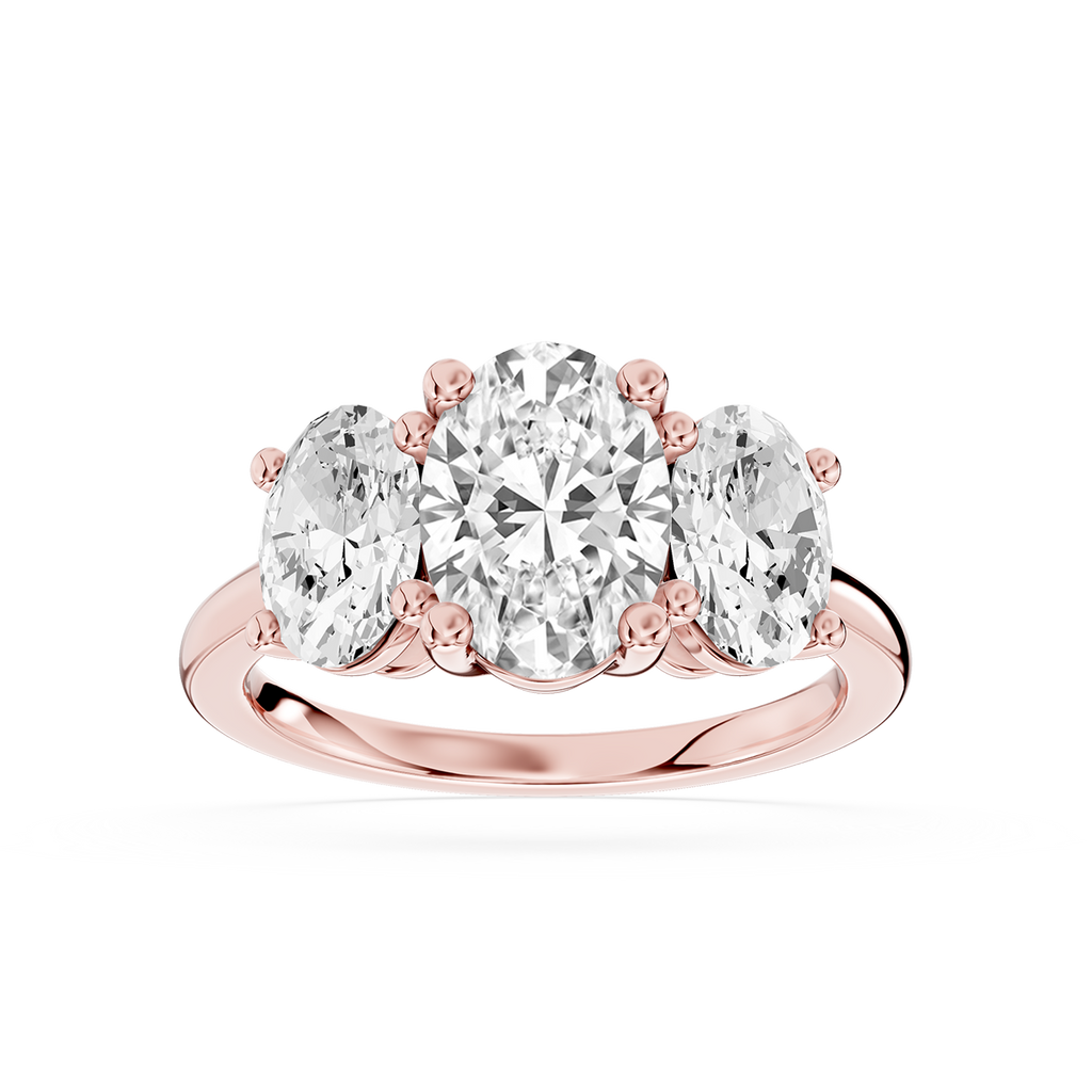 Rose gold oval shaped lab grown diamond trilogy ring featuring three prong set diamonds with a raised center stone